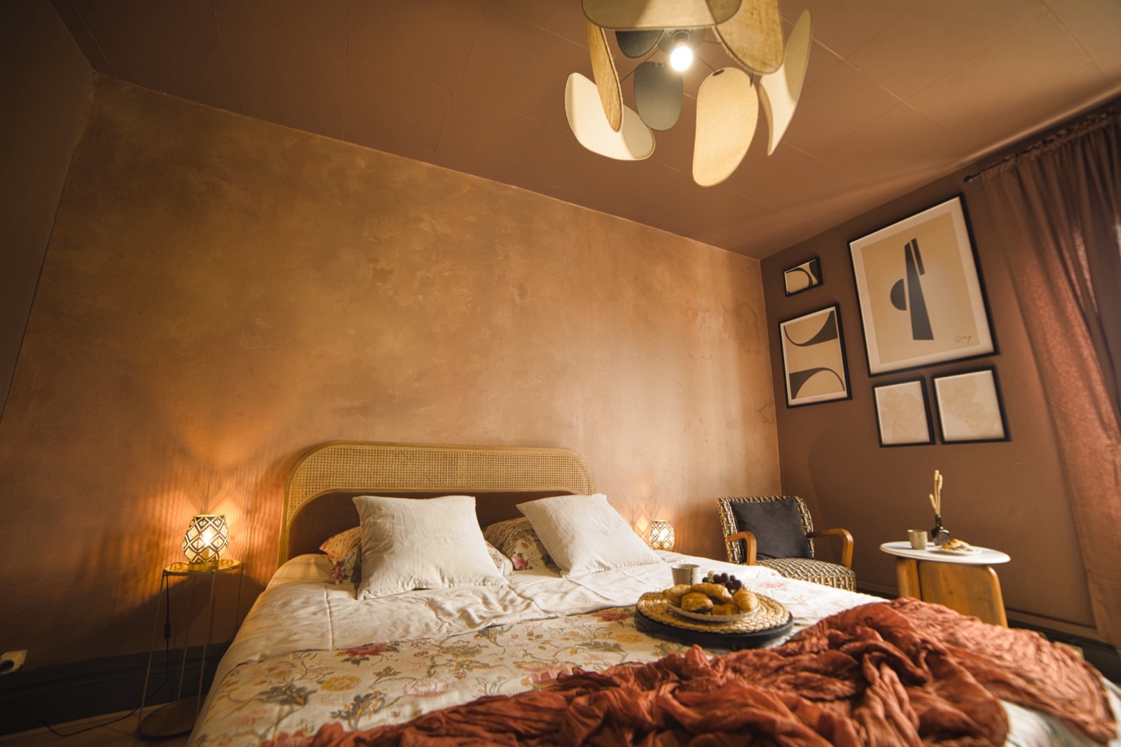 Chambre d'hôtel aux tons terracotta avec petit déjeuner servi au lit