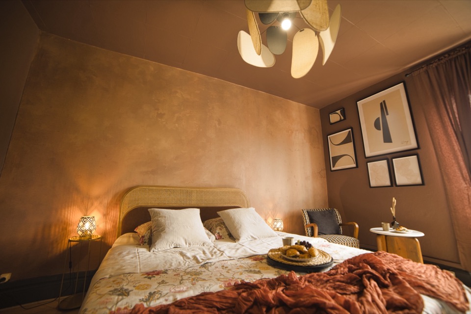 Chambre d'hôtel aux tons terracotta avec petit déjeuner servi au lit