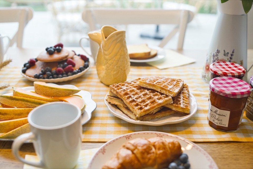 Gaufres, confitures et café sur une nappe vichy jaune