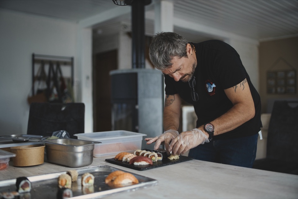 Chef en train de dresser un plateau de sushis sur un plan de travail