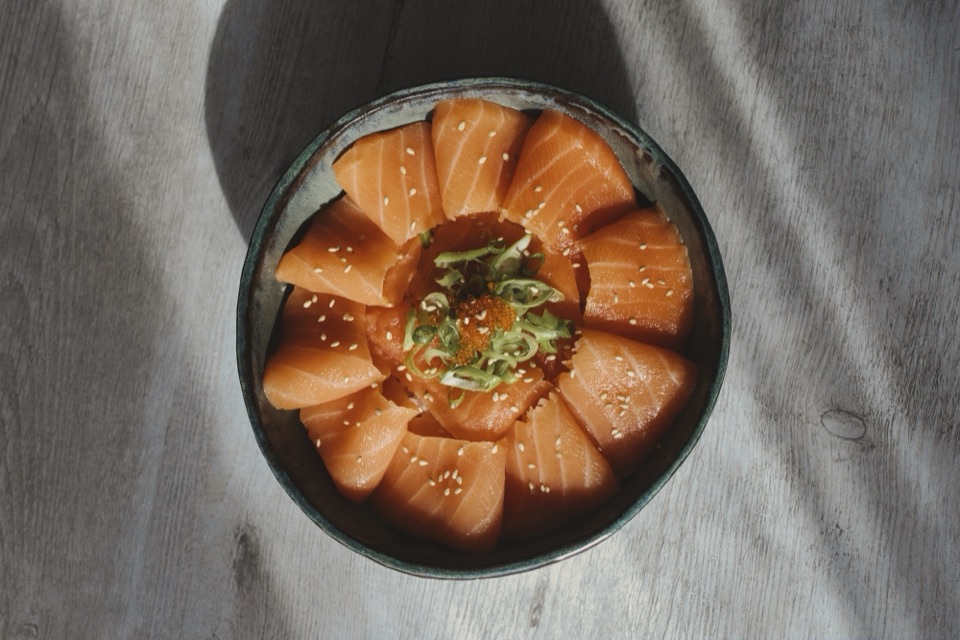 Bol de chirashi au saumon, sésame et ciboule, lumière rasante