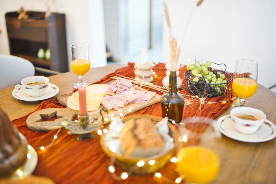 Table de petit déjeuner avec croissants, kouglof, jus d'orange et guirlande
