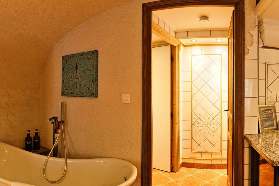 Cave voûtée aménagée avec baignoire sur pieds et cuisine, extrait d'une photo 360°