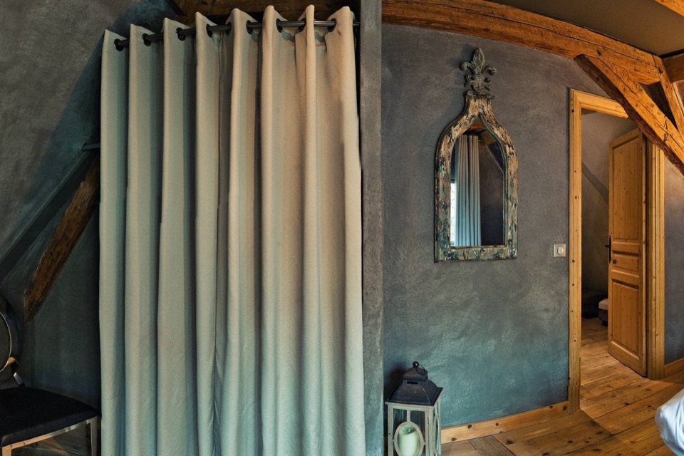 Chambre mansardée aux murs gris et voilages, extrait d'une photo 360°