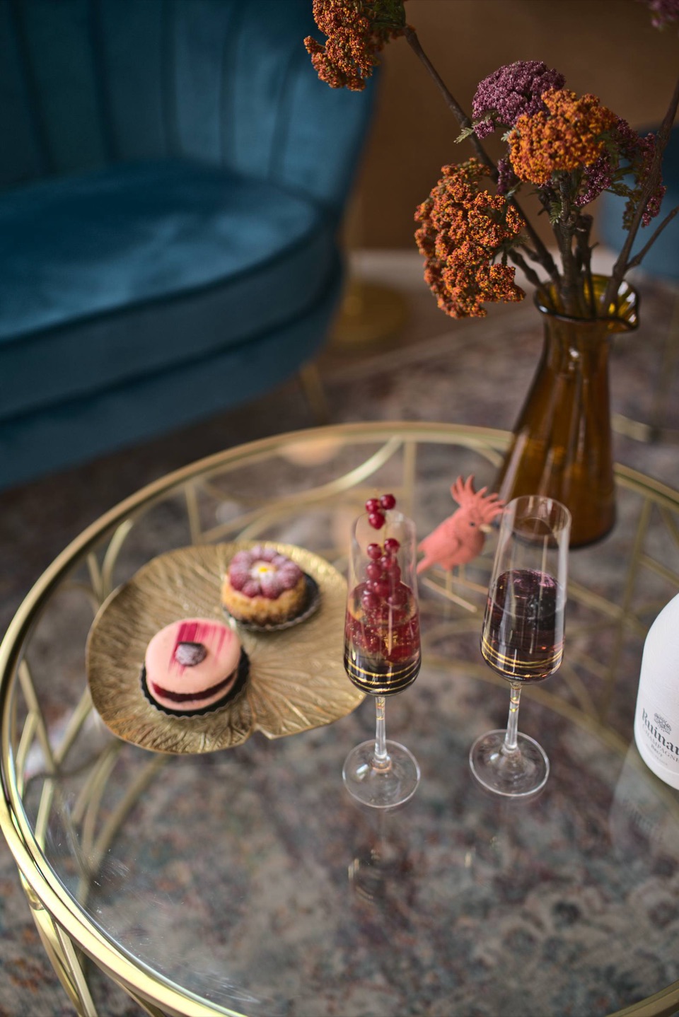 Pâtisseries fines et flûtes de champagne aux groseilles sur table basse dorée