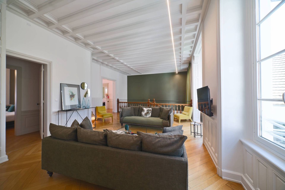 Grand salon haussmannien rénové, plafond à caissons et parquet en chevrons